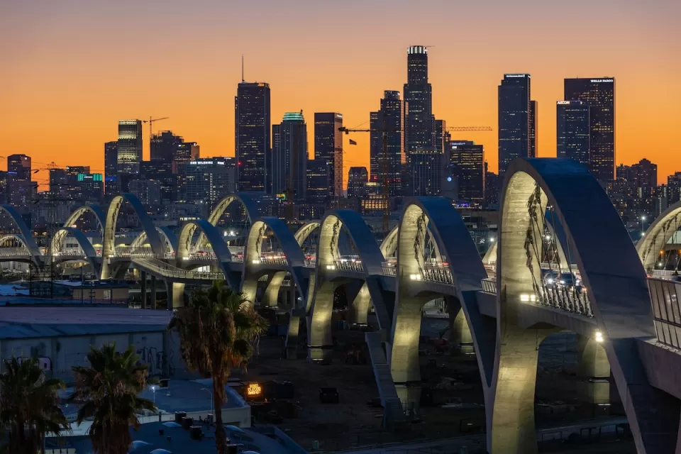 Downtown Los Angeles skyline at sunset with new 6th Street Viaduct arches in foreground.